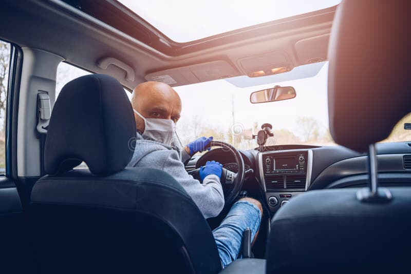 Man in protective medical mask driving a car stock image Man in protective medical mask driving a car stock image
