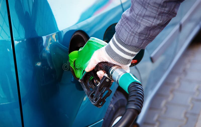 Man pumping gasoline fuel in car at gas station. transportation concept