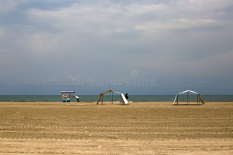 Man pushes his food cart on a desert beach royalty free stock images Man pushes his food cart on a desert beach royalty free stock images