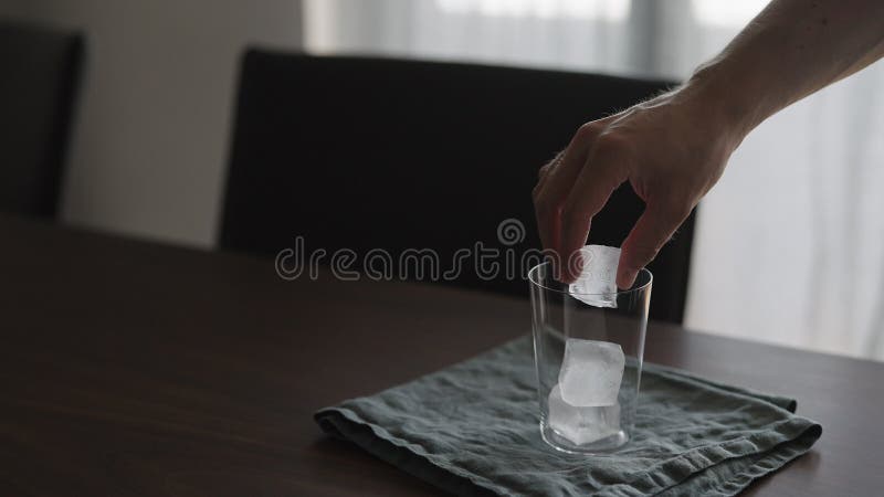 Muž dať pohárik sklo na drevo stôl, široký.