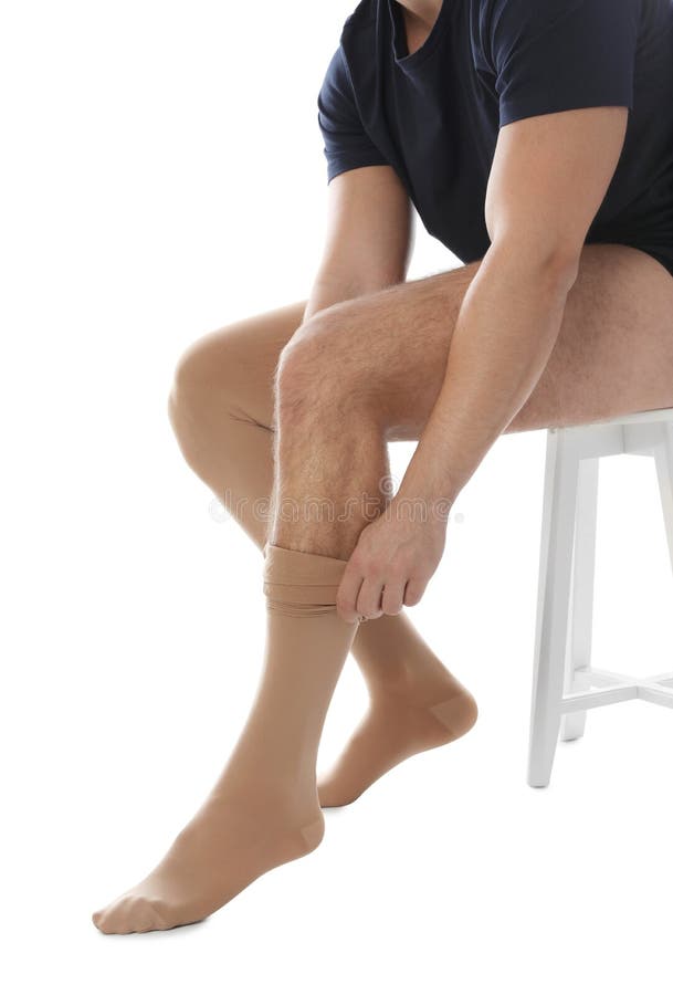 Man putting on compression stocking against white background, closeup