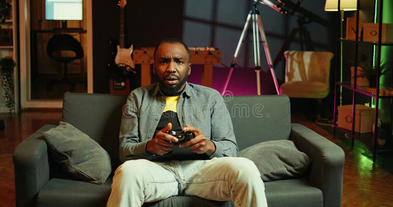 Man putting face in hands in frustration after being defeated in videogame stock image