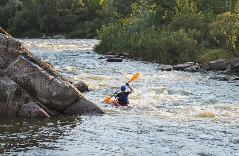 Man rafting with kayak on a fast watercourse