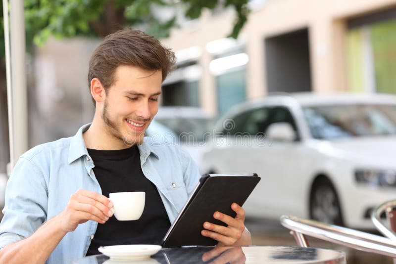 Man reading an ebook or tablet in a coffee shop stock photo Man reading an ebook or tablet in a coffee shop stock photo