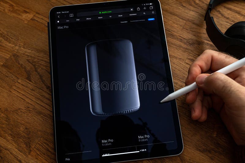 Man reading iPad Pro about mac Pro trash can workstation stock photography