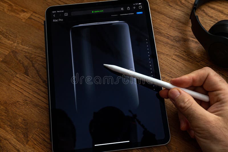 Man reading iPad Pro about mac Pro trash can workstation royalty free stock images