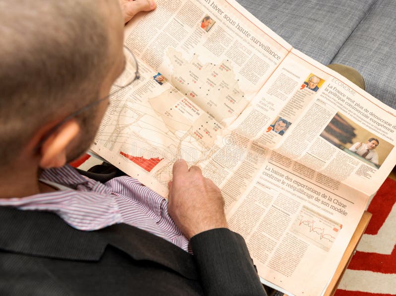 Man reading about nuclear plants in France in newspaper stock photography Man reading about nuclear plants in France in newspaper stock photography