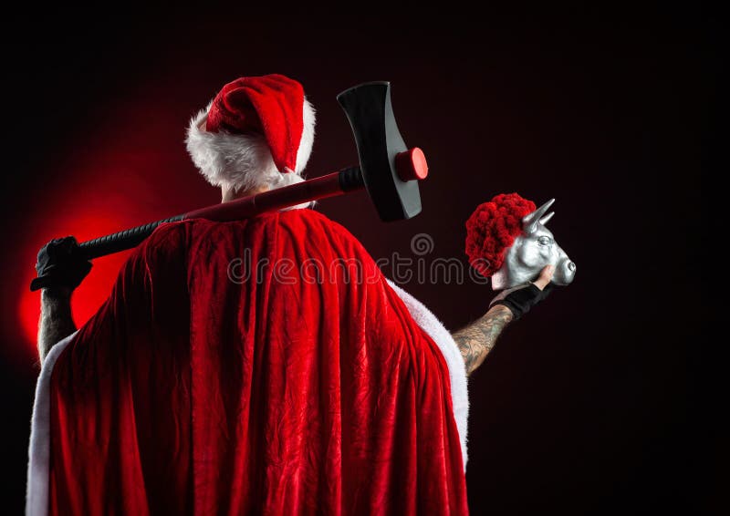 a-man-in-a-red-santa-claus-cape-with-an-axe-and-a-metal-bull-figurine