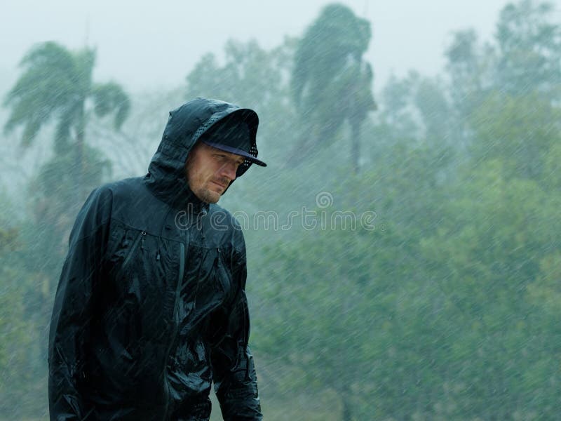 Man in raincoat under heavy tropical rain. Man in raincoat under heavy tropical rain