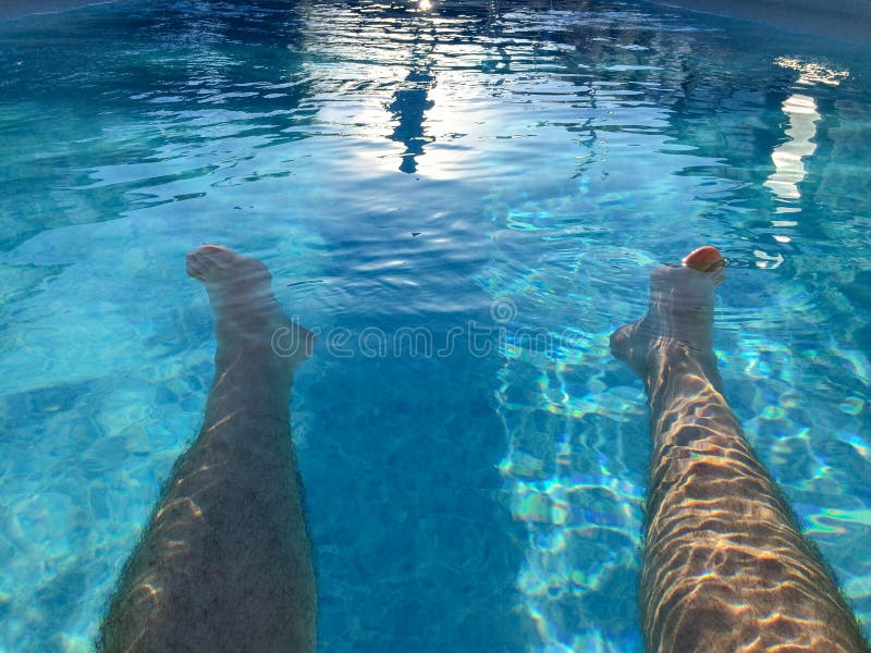 A Man relaxed vacation legs in swimming pool holidays resort