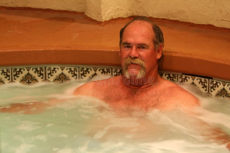 A middle-aged man relaxes in a jacuzzi spa. He has a moustache. A middle-aged man relaxes in a jacuzzi spa. He has a moustache.