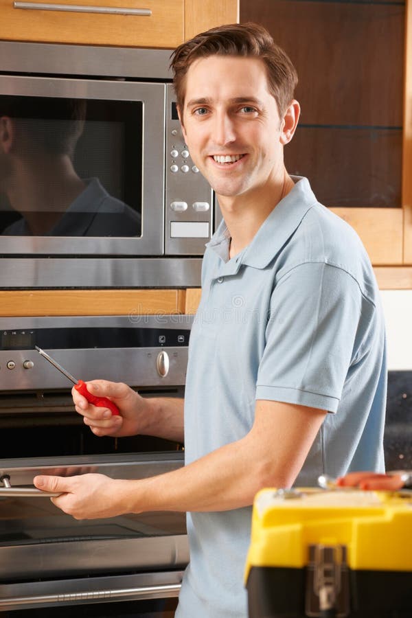 Man Repairing Domestic Oven in Kitchen Stock Photo Image of home