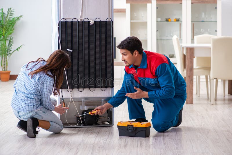 The man repairing fridge with customer