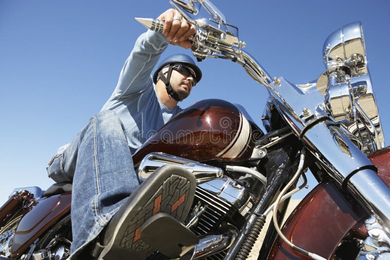 Low angle view of a young men riding motorcycle against clear sky. Clear closeup view stock images, royalty-free photos and pictures