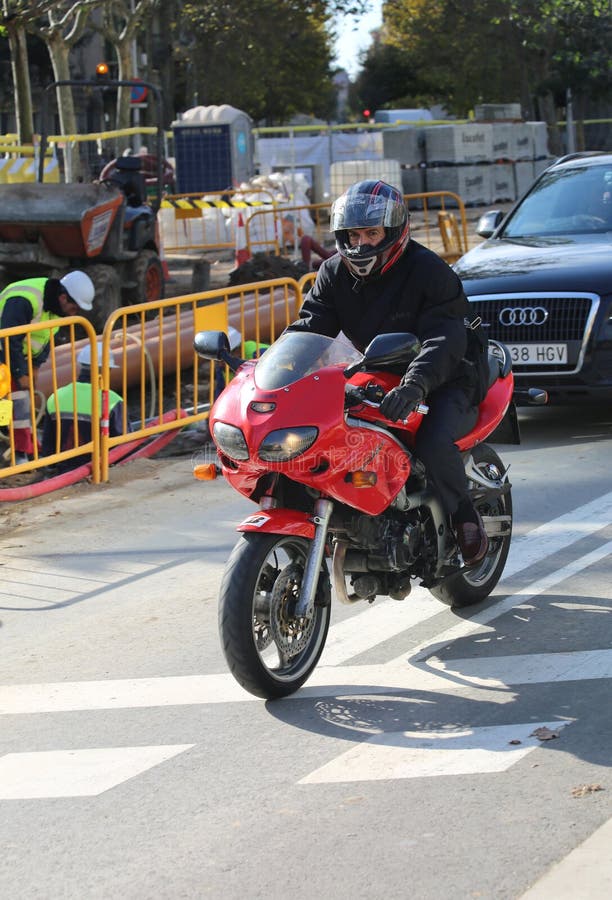 BARCELONA,SPAIN - DECEMBER 6:Man riding a motorcycle near construction.December 6,2014 in Barcelona,Spain.