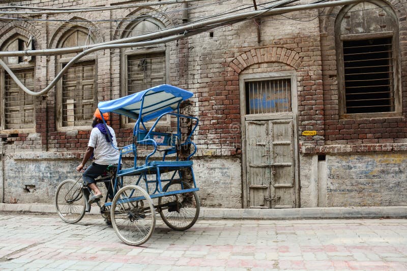 A man riding tricycle on street in Old Delhi, India royalty free stock photography A man riding tricycle on street in Old Delhi, India royalty free stock photography