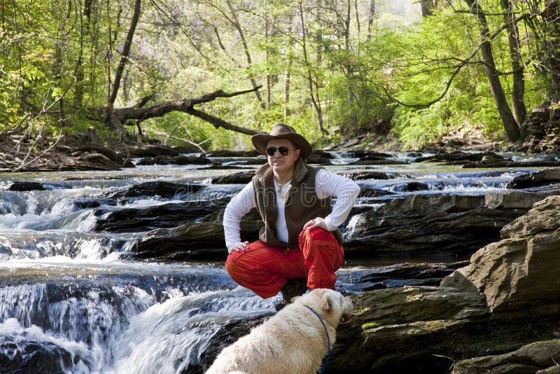 Man in River with Dog Looking to Distance