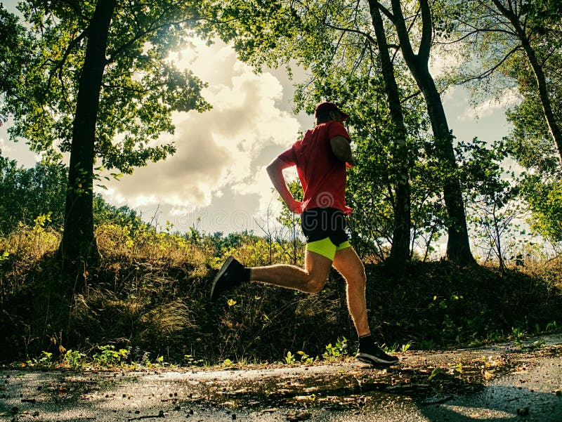 Man Runner In Yellow Black Shorts Pants And Red T Shirt Is Jumping