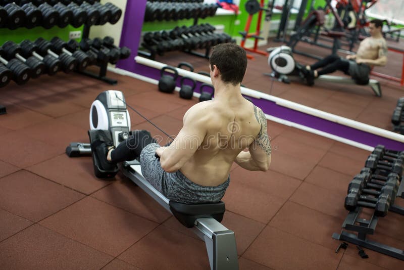 Man in rowing gym exercise stock image. Image of equipment 938179