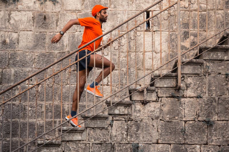 Man Running Up Outdoor Stairs. Well trained sportsman running up outdoor urban stone stairway