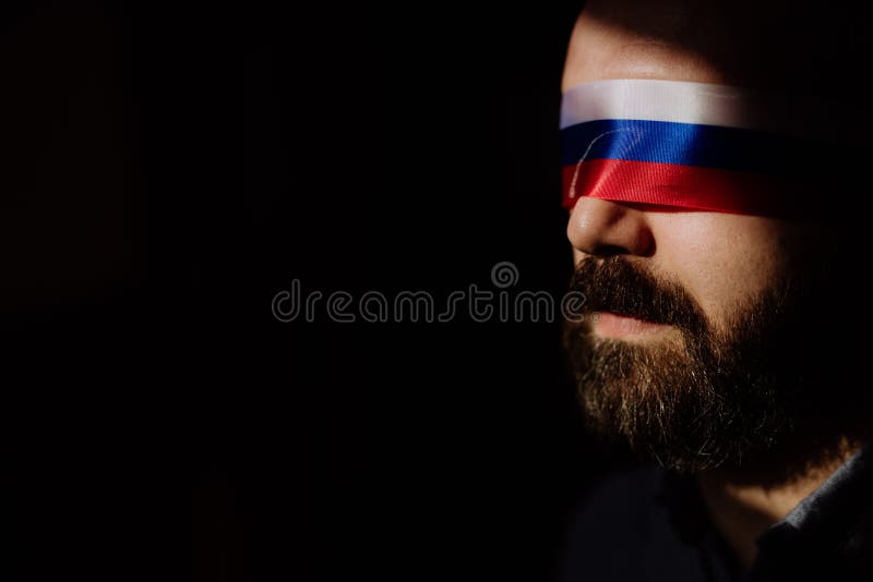 Man with Russian flag blindfold on black background, Russian propaganda closed people& x27;s eyes concept.