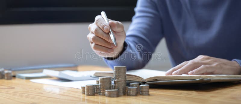 Man counts the coins piled up on the table in preparation to save money, Take note of household financial expenses, Saving money for future growth and knowing how to manage your spending wisely. Man counts the coins piled up on the table in preparation to save money, Take note of household financial expenses, Saving money for future growth and knowing how to manage your spending wisely