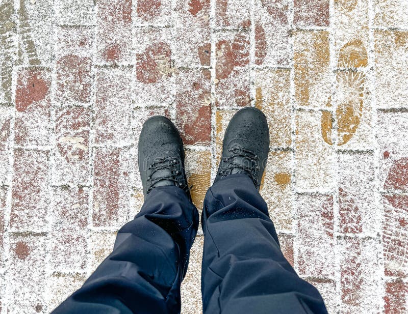 A Man& X27;s Feet on Paving Slabs Covered with Snow Stock Photo - Image ...