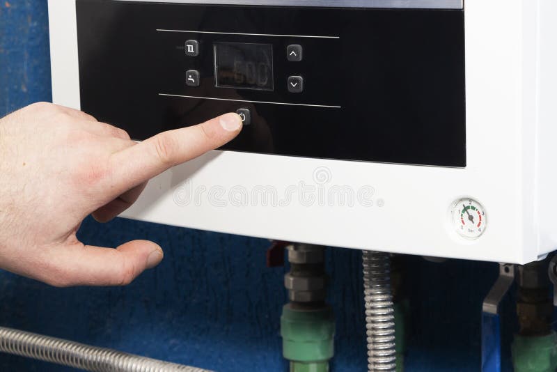 The man`s finger turns on or off the start button of the heating system in the boiler room. The concept of home heating in the