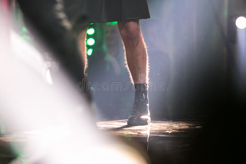 A man`s hairy leg on the stage. With light from behind.