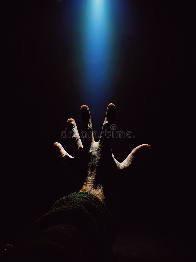 A man& x27;s hand in a dark dugout against the backdrop of a bright beam of light royalty free stock photos