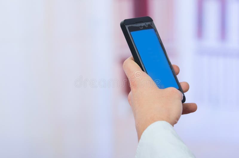 Man's hand holding cell phone with empty blue royalty free stock images