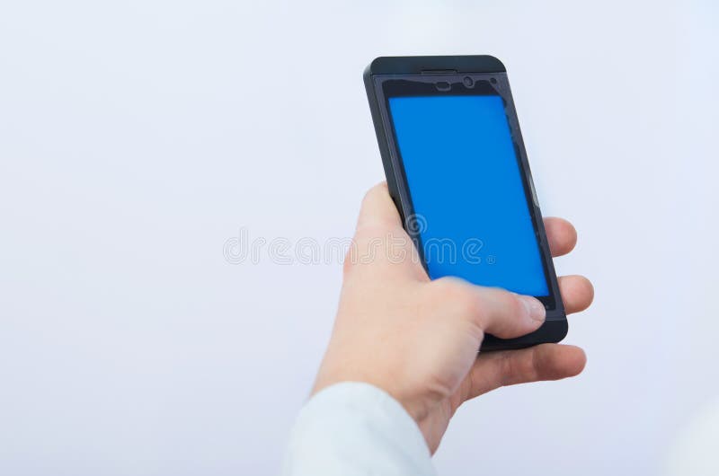 Man's hand holding cell phone with empty blue stock photos