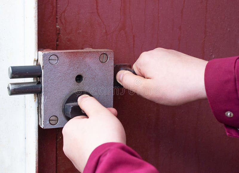 A man`s hand opens the lock on the front iron door from the street.