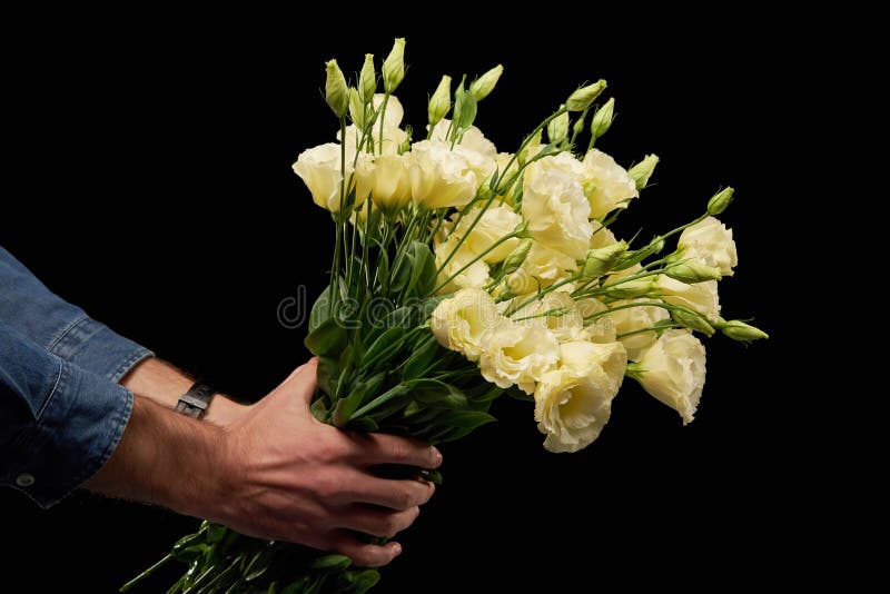 Man`s hand presenting a bunch of flowers