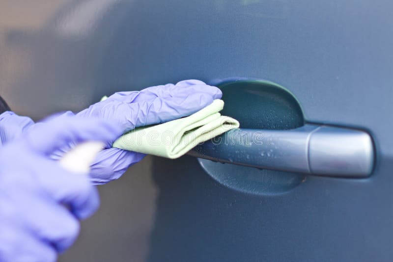 Man`s Hand in Protective Gloves Cleaning Car Door Handle Using