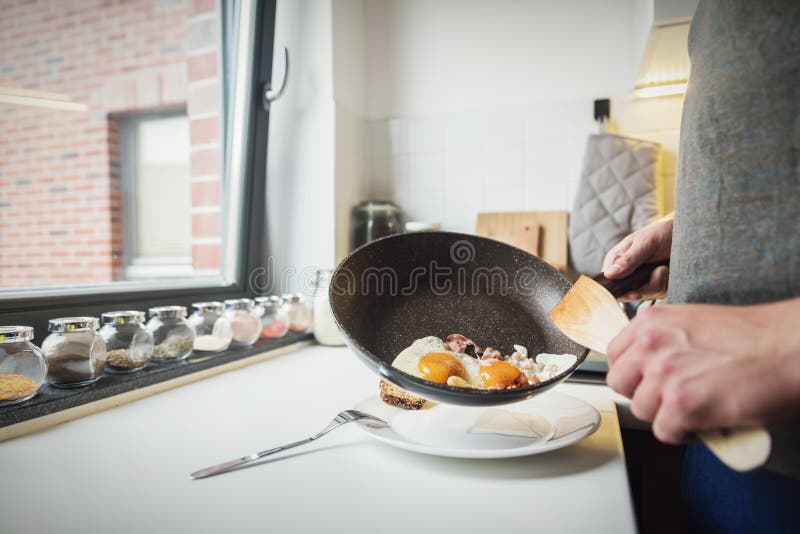 Man putting fried eggs on the plate