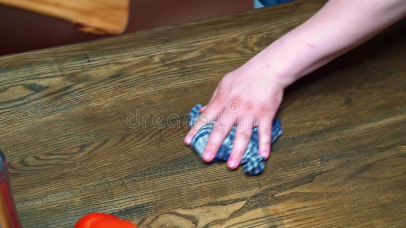 the man's hand wipes the table and cutting board with a rag. kitchen