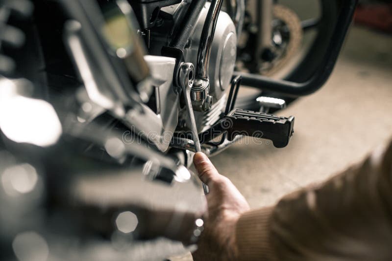 Man`s hands holding wrench. Fixing motorcycle concept