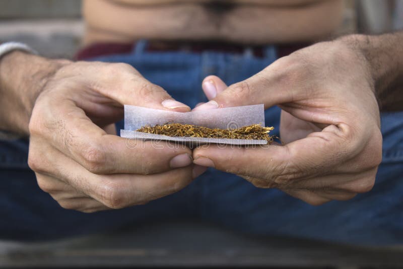 Man`s hands rolling a joint stock image Man`s hands rolling a joint stock image