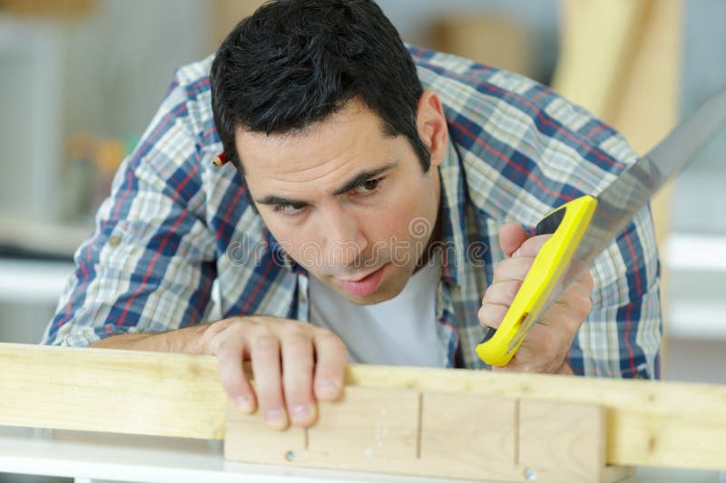 Man sawing cutting wood board stock image