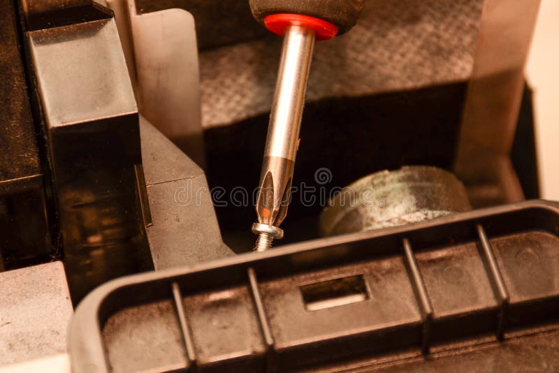 A Man with a Screwdriver Assembles a Printer. Repair of Office