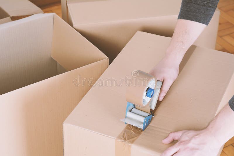 Man sealing a shipping cardboard box stock image Man sealing a shipping cardboard box stock image