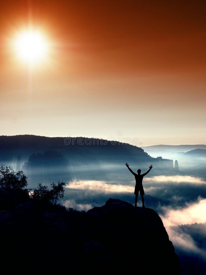 Happy man gesture raised arms. Funny hiker with raised hands in the air on rock edge in national park. Vivid and strong vignetting effect. Happy man gesture raised arms. Funny hiker with raised hands in the air on rock edge in national park. Vivid and strong vignetting effect.