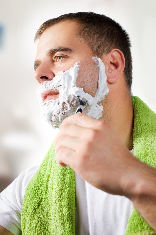 Man shaves his face stock photo. Image of clean, shave 61117304