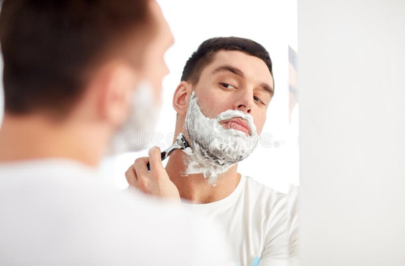 Man Shaving Beard With Razor Blade At Bathroom Stock Photo
