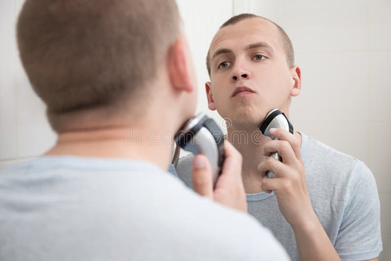 Man Shaving with Electric Razor in Bathroom Stock Photo Image of