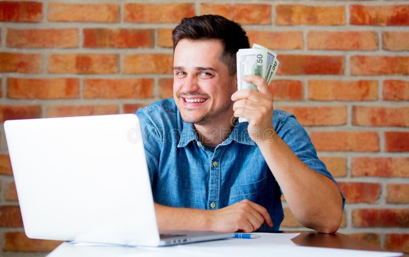 Man in shirt with laptop computer and money