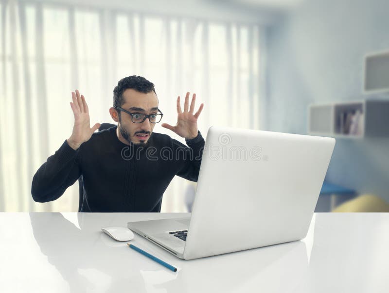 Man Shocked Reading Message on Computer in Office stock photos