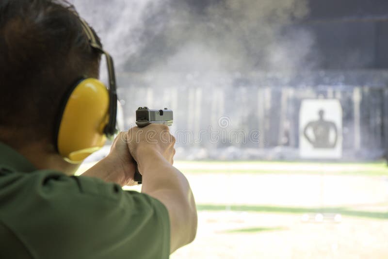 Law enforcement aimimg and shooting gun in academy shooting range surround with smoke and copy space. Law enforcement aimimg and shooting gun in academy shooting range surround with smoke and copy space