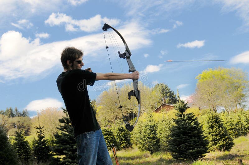 Young adult man shooting an arrow in mid air. Young adult man shooting an arrow in mid air